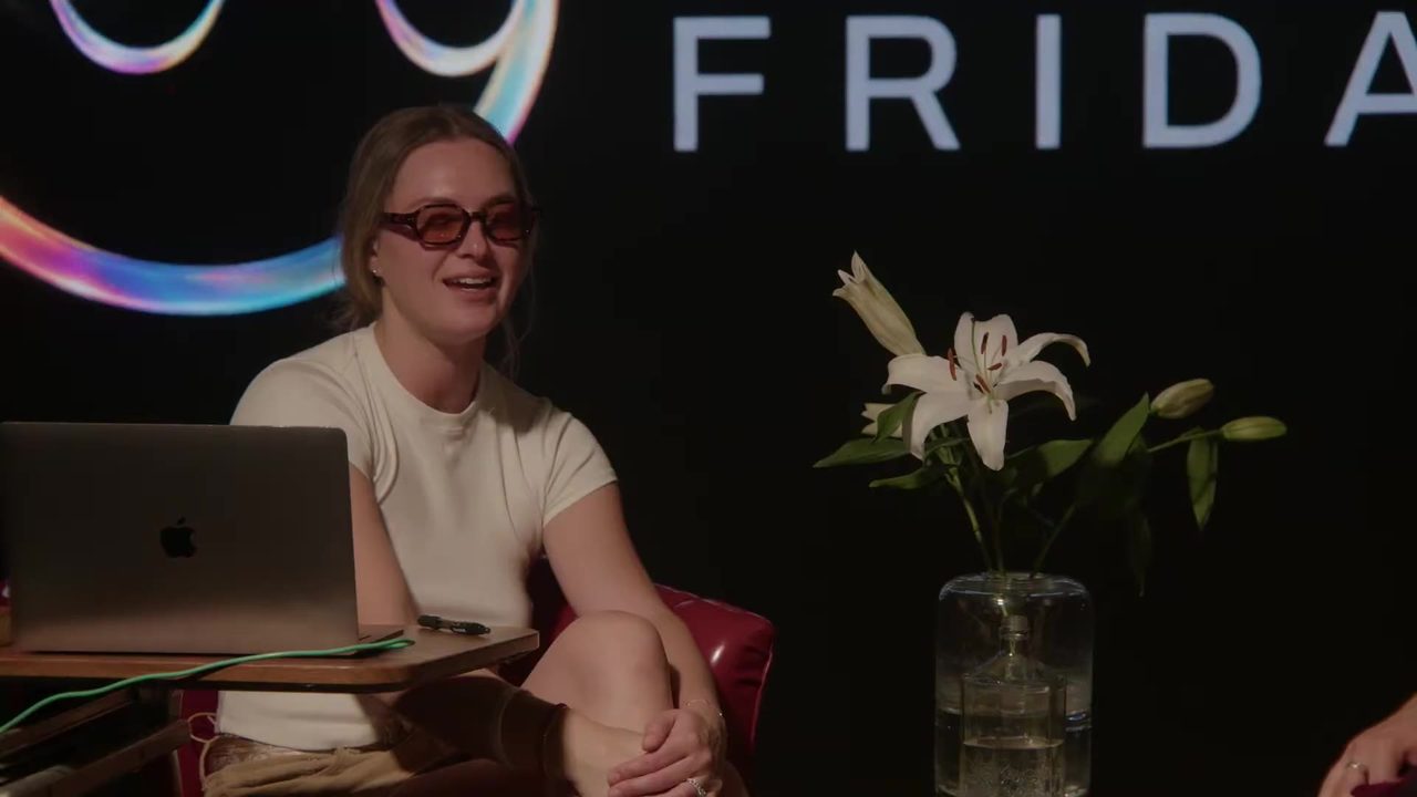 Taylor laughing in the Living Room, in front of the Frequency Friday logo